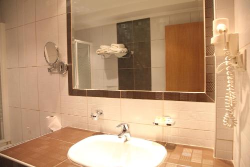 a bathroom with a sink and a mirror at Pantelidis Hotel & Spa in Ptolemaida
