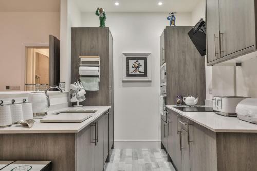 a large kitchen with wooden cabinets and a sink at The Hepburn - Top Floor - Luxury for up to 6 guests near Open Air Theatre and North Bay in Scarborough