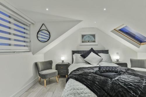 a bedroom with a bed and two chairs and a window at The Hepburn - Top Floor - Luxury for up to 6 guests near Open Air Theatre and North Bay in Scarborough