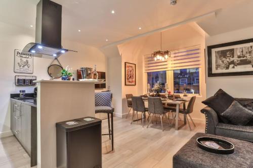 a kitchen and living room with a table and chairs at The Hepburn - Top Floor - Luxury for up to 6 guests near Open Air Theatre and North Bay in Scarborough