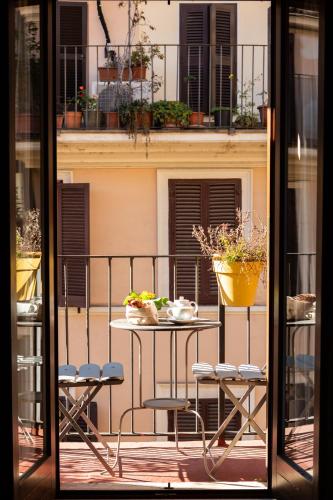 a balcony with a table and chairs on a balcony at Hotel Piazza Di Spagna in Rome