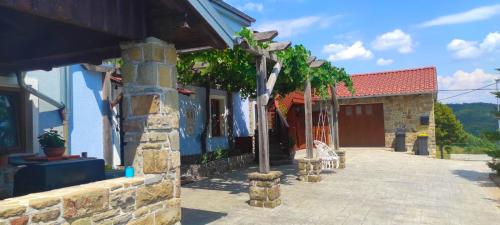 a building with a stone pillar and a building with trees at ADORI in Ilirska Bistrica