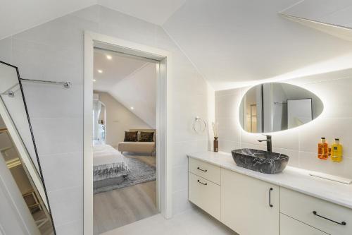 a white bathroom with a sink and a mirror at Douro Prestige Urban Retreat with shared S-Pool & Gym in Porto