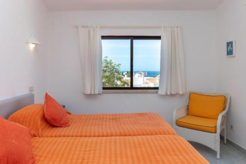 卡武埃魯的住宿－Casa Figueira，一间卧室设有两张床、一个窗口和椅子