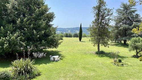 a park with tables and chairs in the grass at Manoir de La Brunie-Grand Longere in Coux-et-Bigaroque