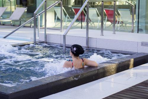 a woman in a hot tub in a swimming pool at Estival Park Almaris in La Pineda