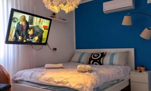 a bedroom with a tv hanging above a bed at נגיעות הגולן in Moshav Ramot
