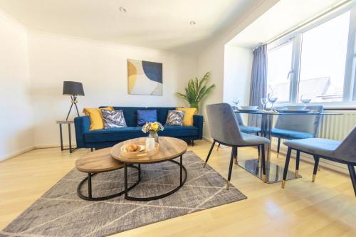 a living room with a blue couch and a table at Modern 4-Level Townhouse for 8 Free Parking Bournemouth in Bournemouth
