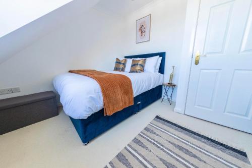 a bedroom with a bed with white walls and a door at Modern 4-Level Townhouse for 8 Free Parking Bournemouth in Bournemouth
