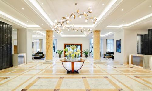 eine Lobby eines Hotels mit einem Kronleuchter in der Unterkunft InterContinental Athenee Palace Bucharest, an IHG Hotel in Bukarest