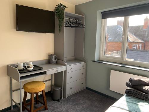 1 dormitorio con escritorio, 1 cama y ventana en The Bridge Inn en Tenbury