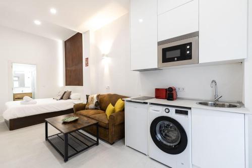 salon z kanapą i pralką w obiekcie Apartamento amplio y coqueto a solo 750m Bernabeu w Madrycie