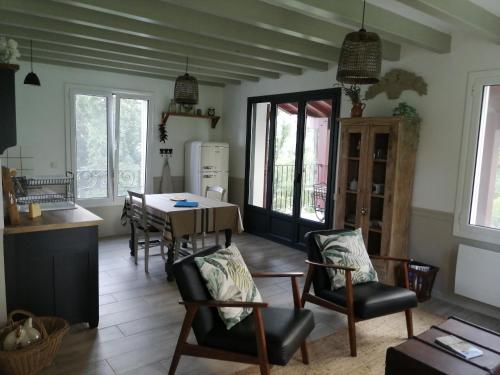 a kitchen and dining room with a table and chairs at VILLA XARAN ERDIAN Gîte LA PETITE MAISON in Espelette