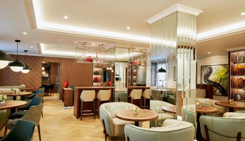 a restaurant with tables and chairs and a chandelier at InterContinental Athenee Palace Bucharest by IHG in Bucharest