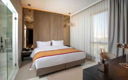 1 dormitorio con 1 cama grande y escritorio en Hotel Royal ASBU Tunis en Túnez
