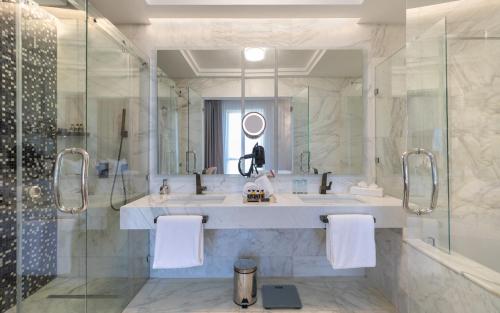 a bathroom with a shower and a sink and a mirror at Hotel Royal ASBU Tunis in Tunis