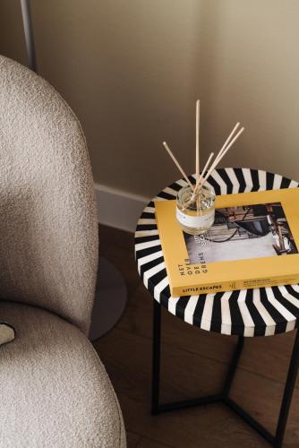 a table with a book and a chair and a table with a book at Adam Suites Hotel in Amsterdam