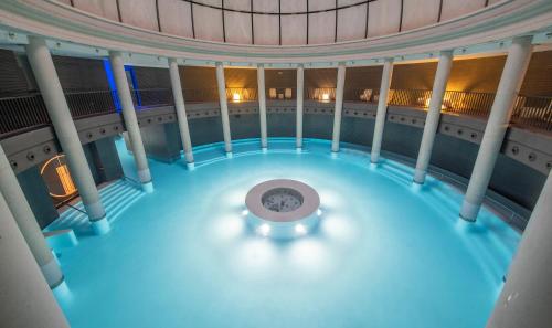 an indoor pool with a clock in the middle of a building at Las Caldas by blau hotels in Las Caldas