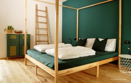 a green bedroom with a bed with a ladder at Foresteria Cà di Nadin in Carriola