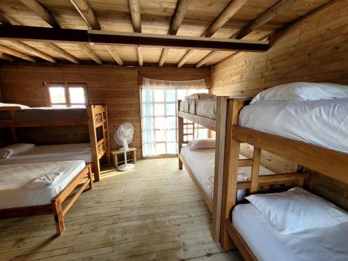 a room with several bunk beds in a cabin at Hostel villa luz Beach in Tintipan Island