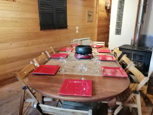 - une table en bois avec des serviettes rouges et des verres à vin dans l'établissement Chalet View on Vanoise Mountain - 2 bedrooms 70m2, à Cevins