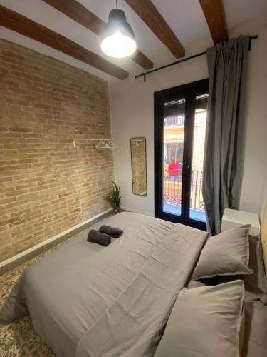 ein großes Bett in einem Zimmer mit Ziegelwand in der Unterkunft Spacious Modern Apartment in the Vibrant El Raval in Barcelona