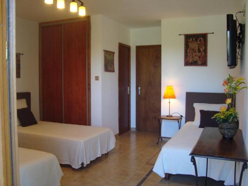 Un dormitorio con 2 camas y una mesa con flores. en Chambres d'hôtes Les Palmiers de la Cité, en Carcassonne