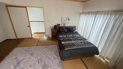 a bedroom with two beds and a dresser and a window at ELM On The Beach in Kitaibaraki