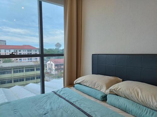 - une chambre avec un lit et une grande fenêtre dans l'établissement Kozi ONE Homestay Infinity pool & Gym 2Rooms, à Kuching