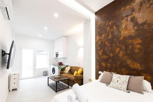 1 dormitorio con cama blanca y pared grande en Loft situado cerca del Santiago Bernabéu, en Madrid