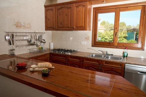 a kitchen with a wooden counter top and a sink at Casa Nuria in L'Ampolla