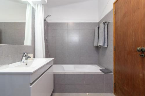 uma casa de banho com uma banheira e um lavatório em Colina Azul em Carvoeiro