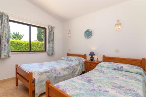 カルヴォエイロにあるColina Azulのベッドルーム1室(ベッド2台、窓付)