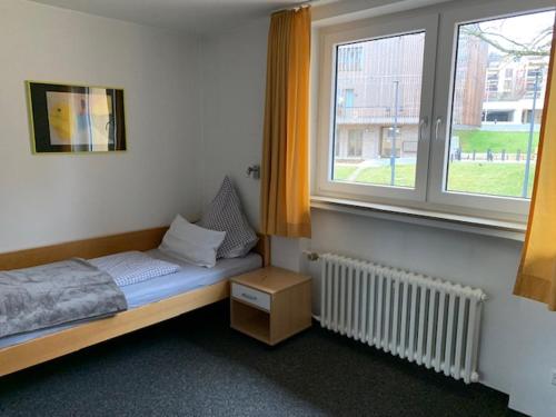 1 dormitorio con cama y ventana con radiador en Topp Apartments, en Tübingen