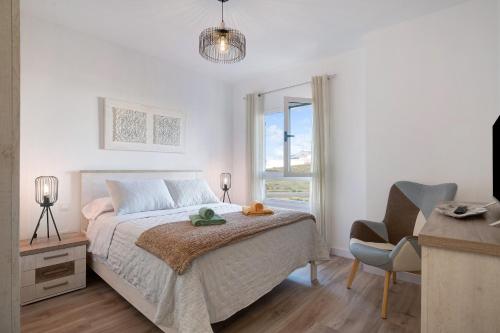 um quarto com uma cama, uma cadeira e uma janela em Casa Reguemar em Arrecife