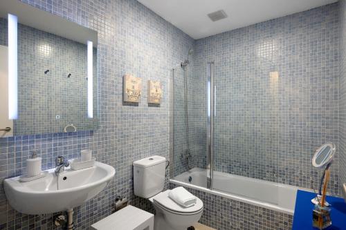 uma casa de banho em azulejos azuis com um lavatório e um WC em Casa Reguemar em Arrecife