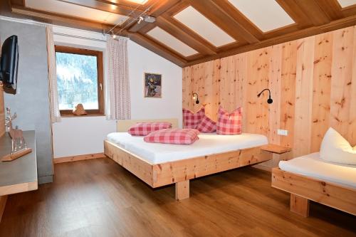 a bedroom with two beds in a room with wooden walls at Wannig in Biberwier