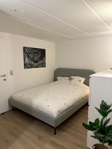 1 dormitorio con 1 cama en una habitación blanca en Le Cottage, en Lasne