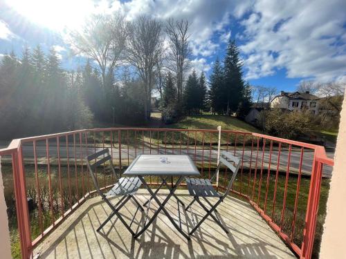 una mesa y dos sillas sentadas en una terraza en Les Jonchères en Luxeuil-les-Bains