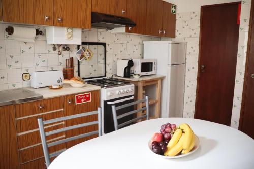 a kitchen with a table with a bowl of fruit on it at Cantinho dos avós in Fuzeta