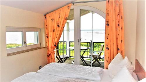 een slaapkamer met een bed en een balkon met een tafel bij Baltic View in Glowe
