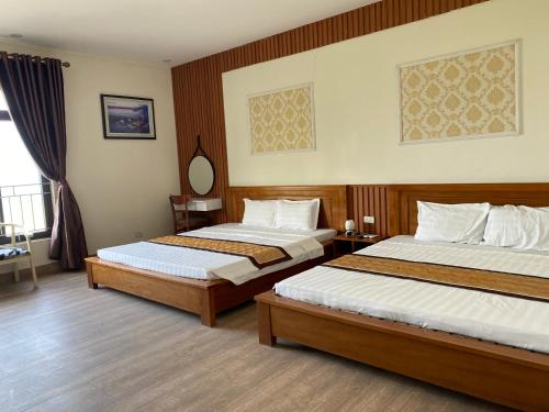 pokój hotelowy z 2 łóżkami i oknem w obiekcie Hottel HÙNG PHƯƠNG cô tô w mieście Đảo Cô Tô