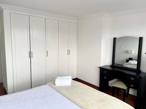 um quarto com uma cama, um espelho e uma cômoda em Suite amoblada con aparcamiento privado excelente vista y ubicación! Sector La Carolina em Quito