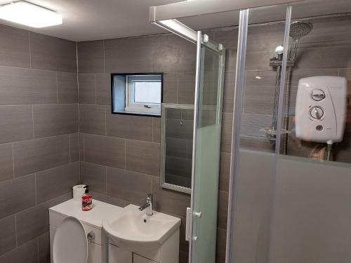 a bathroom with a toilet and a sink and a shower at Sandhaven Beach Chalets in South Shields