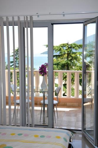 a room with a balcony with a view of the ocean at Montesun Residence in Herceg-Novi