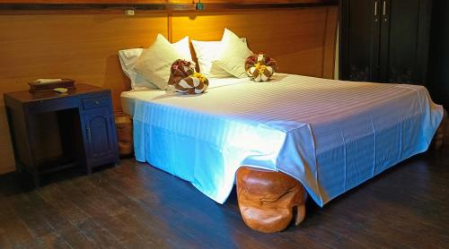 a bed with two stuffed animals sitting on top of it at Stargate Villa Pintu Bintang in Pawenang