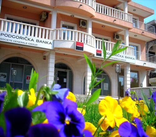 a building with flowers in front of it at Montesun Residence in Herceg-Novi
