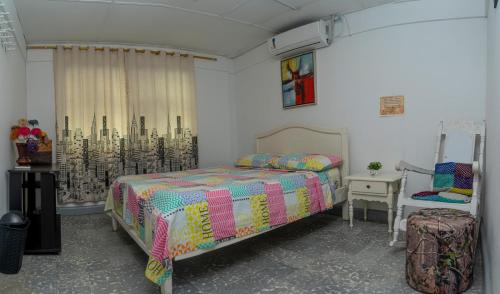 ein Schlafzimmer mit einem Bett mit einer bunten Bettdecke in der Unterkunft Casa Zaida Hostal Vintage in Ríohacha