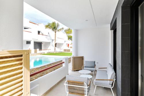 un patio avec des chaises et une piscine dans l'établissement Apartment Tropical Beach, à San Javier