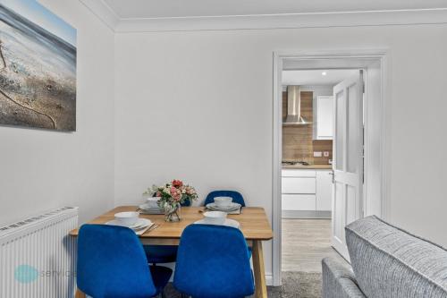 a dining room with a table and blue chairs at 3 Bed- The Barracks in Plymouth